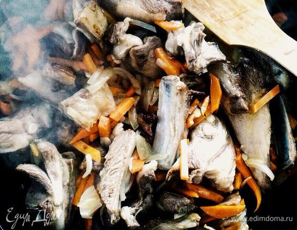 Добавляем к баранине овощи (лук, морковь) и жарим в течение 10 минут.