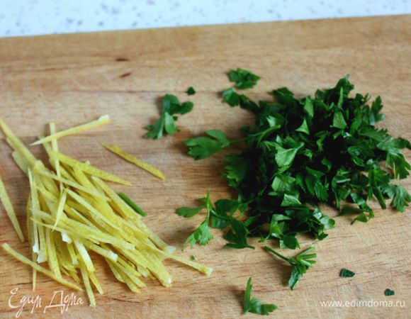 Лимон вымыть горячей водой, снять цедру теркой или овощечисткой и тонко нарезать. Залить цедру ледяной водой. Из лимона выжать сок. Петрушку помыть, обсушить и нарезать.