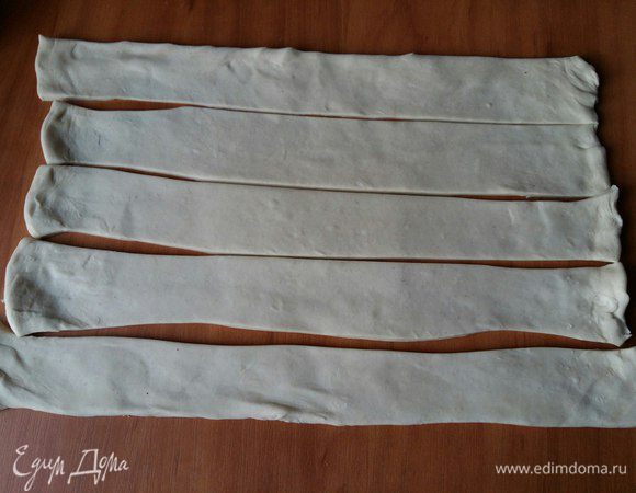 Заранее разморозим тесто (слоеное бездрожжевое). Возьмем 1 пласт, раскатаем его длиной 25-30 см, нарежем на полосочки шириной примерно 4 см. 