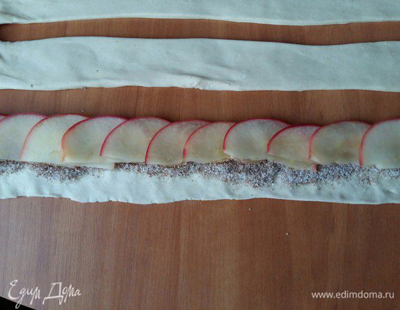 Берем наши дольки и укладываем внахлест на полоску теста от начала до конца.