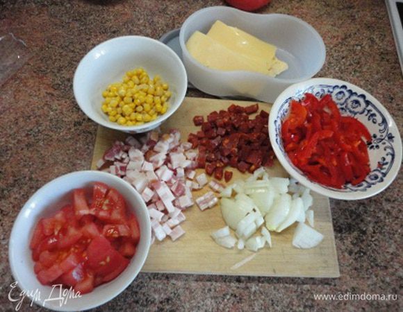Колбасу (я взяла чоризо и уже не добавляла перца, хватило ее остроты), бекон и лук нарезать кубиками. Перец — полосками. Помидор предварительно очистить от кожицы с помощью кипятка и холодной воды и нарезать также кубиками. Сыр нарезать слайсами.