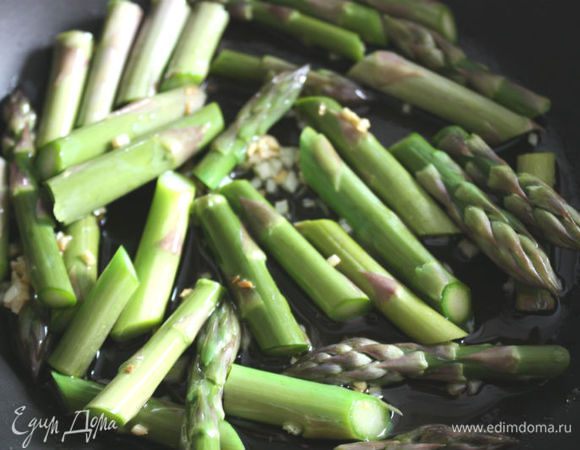 Пока варятся спагетти, очистить и порубить чеснок.
В сковороде нагреть оливковое масло, на маленьком огне пассеровать чеснок, затем добавить сливочное масло  и спаржу. Готовить под крышкой 4-5 минут, приправить солью и перцем, добавить горошек, чили и спагетти, осторожно перемешать, накрыть и готовить еще 2-3 минуты на минимальном огне. Перед подачей добавить петрушки.