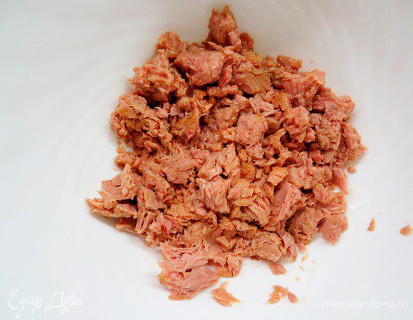 Консервированного тунца выложить в миску (лишний сок предварительно слить), размять вилкой.