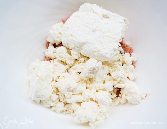 Добавить в миску с тунцом раскрошенную фету и творог. 