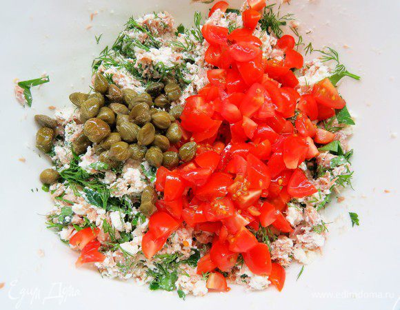 Нарезать зелень (у меня укроп и петрушка), помидоры нарезать кубиками. Добавить к тунцу с творогом и фетой нарезанную зелень, помидоры и каперсы.