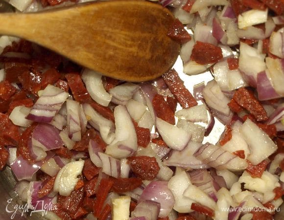 Чоризо очистить от оболочки. Нарезать мелкими кусочкам. Лук (вес лука в очищенном виде получился 160 г) очистить, мелко нарезать. В глубокой сковороде обжариваем чоризо, пока не станет выделяться жир. Когда чоризо начнет выделять жир, добавить к нему нарезанный мелко лук. Обжаривать, постоянно помешивая, пока лук не станет прозрачным.