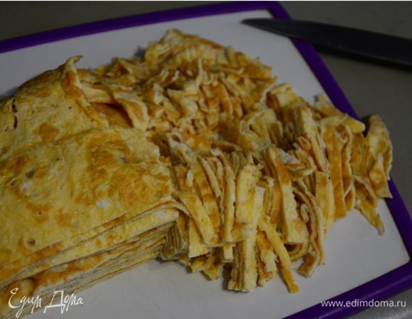 Готовые яичные блины остудите, нарежьте на 4 части, а затем — соломкой.
