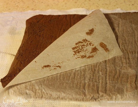 Готовый бисквит выложить на чистое полотенце пергаментом вверх. Аккуратно удалить бумагу.
