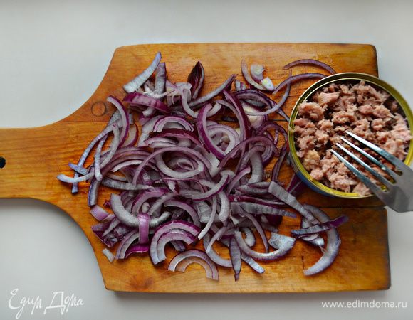 Лук порезать тонкими полукольцами. Тунец разделить на небольшие кусочки с помощью вилки прямо в банке.
