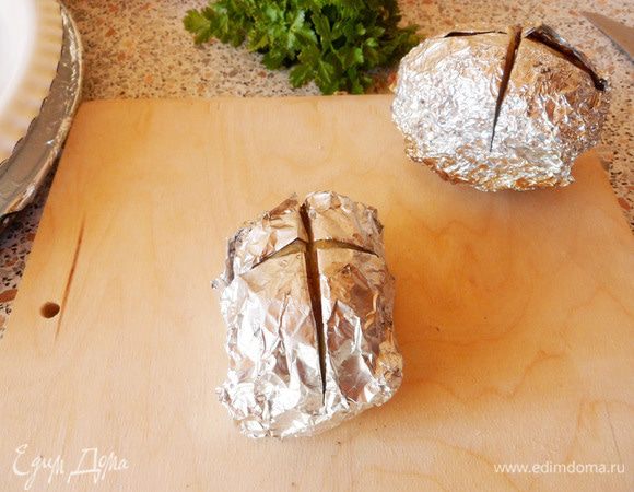 Надрезаем картофель в фольге крестообразно, примерно до середины.
