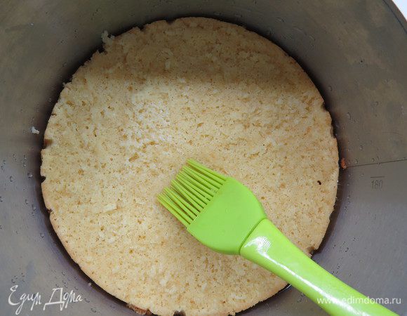 Собираем торт. Бисквит разрезать на два коржа. Выложить первый корж, пропитать кокосовым сиропом.