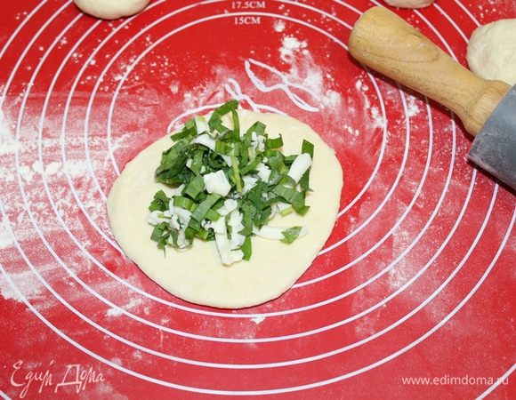 Тесто разделить на 10-12 кусочков. Раскатать каждый кусочек в лепешку, выложить начинку.