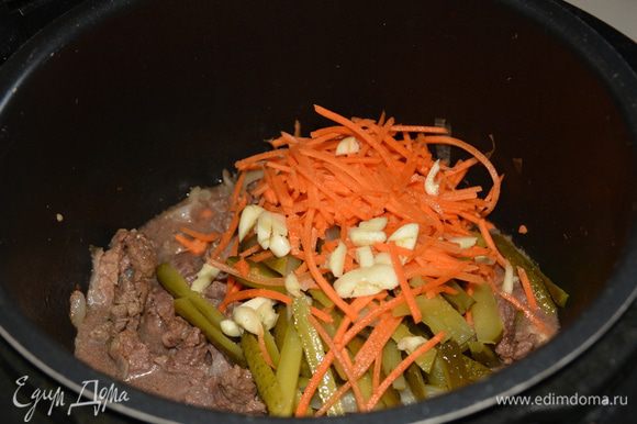 После окончания режима выпустить пар, открыть крышку и добавить морковь, огурцы, мелко нарезанный чеснок. Если чеснок свежий, то достаточно будет и 1 дольки. Перемешать.