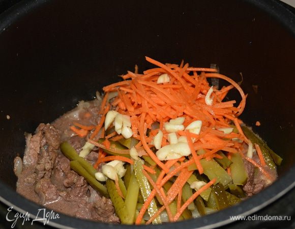 После окончания режима выпустить пар, открыть крышку и добавить морковь, огурцы, мелко нарезанный чеснок. Если чеснок свежий, то достаточно будет и 1 дольки. Перемешать.