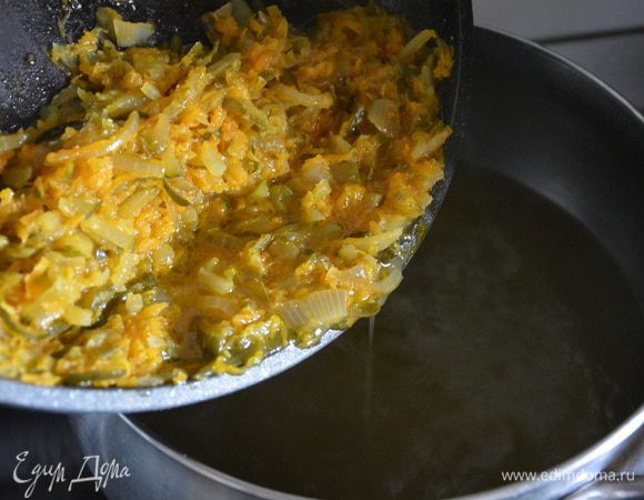 Добавить пассерованные овощи в кипящий бульон.