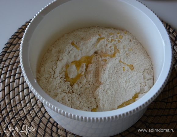 Как только появилась шапочка на дрожжевой смеси, добавить к ней оставшиеся 200 мл теплого молока, растопленное сливочное масло. Перемешать. Постепенно добавить муку, может понадобиться больше или меньше. Тесто должно быть слегка липким. 