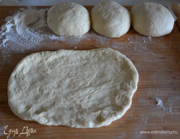 Разделить тесто на 4 части, скатать колобки. Старайтесь не забивать тесто мукой, оно все еще должно быть липким.