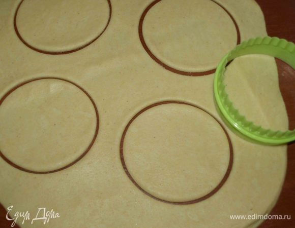 На сухой поверхности раскатать тесто. Присыпать мукой не надо, в этом нет необходимости. Тесто не пристает. Вырезаем кружки нужного размера (у меня 7,5 см).