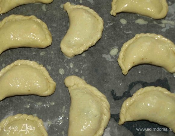 Противень застилаем пекарской бумагой, смазываем маслом и выкладываем эмпанадас. Смазываем эмпанадас взбитым яйцом и отправляем в разогретую до 230°С духовку на 12-15 минут.  