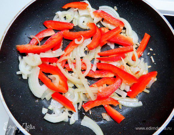 Убавляем огонь и добавляем оставшееся масло. Выкладываем на сковороду лук и чеснок, пассеруем до прозрачности. 