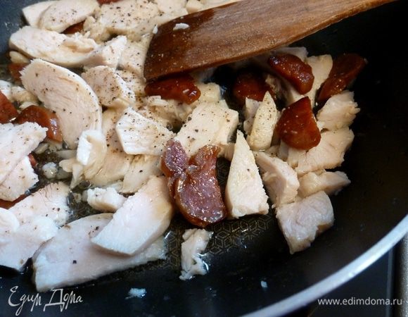 Колбаску чоризо нарежем полукольцами, немного поджарим. Затем добавим куриную грудку, готовится она быстро. Когда побелеет, значит, пора добавлять следующие ингредиенты.