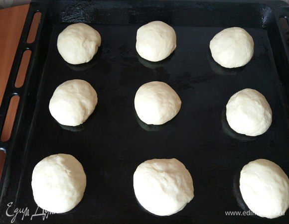 Берем наше тесто, делим на кусочки. Каждый кусочек скатаем на столе в шарик, выложим на смазанный растительным маслом противень на расстоянии друг от друга. У меня получилось 13 штук. Пекла за 2 раза.