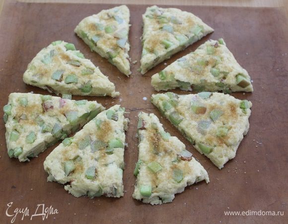 Распределить тесто руками на бумаге для выпечки, разрезать на сегменты, раздвинуть сегменты друг от друга, смазать молоком, посыпать сахаром.