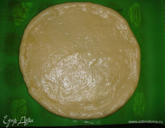Выложить тесто на силиконовый коврик (или на смазанный маслом противень) и раскатать в форме круга, делая края немного толще середины. 
