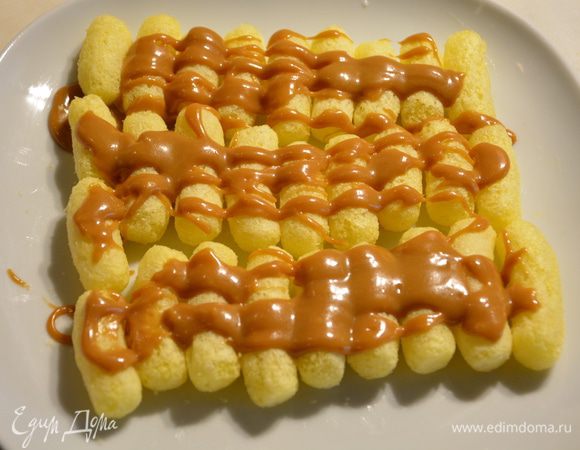 Сложите кукурузные палочки рядами. Сверху полить карамелью.