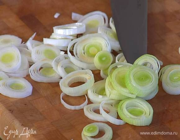 Светлую часть лука-порея нарезать тонкими кольцами.