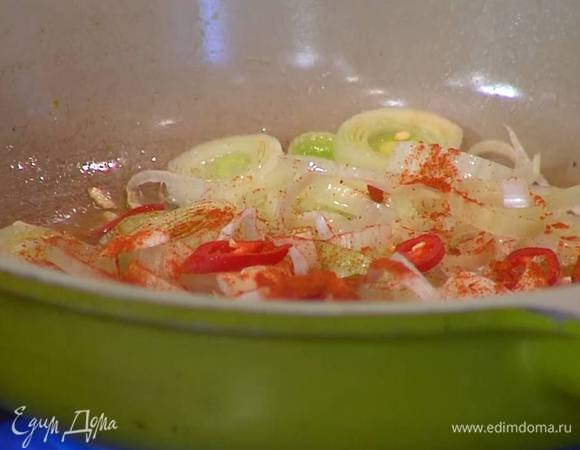 Перец чили нарезать тонкими колечками и отправить к луку с чесноком, всыпать сладкую паприку и все перемешать.