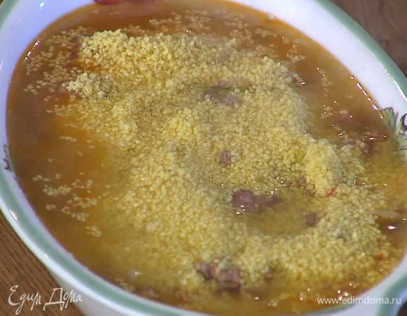 В жаропрочную форму выложить фарш с овощами, сверху насыпать кускус и залить горячим бульоном, так чтобы все было полностью покрыто.