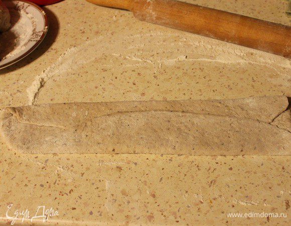 Затем сложить края по длинной стороне к середине. Слегка раскатать скалкой.
