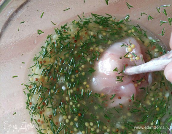 Берем крылышки и по очереди каждое окунаем в маринад.