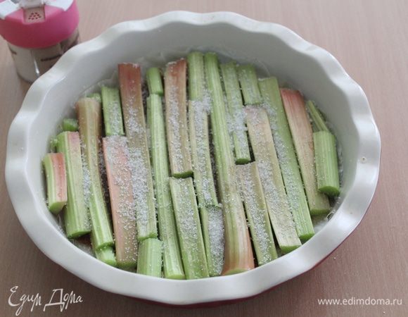 Сверху выложить стебли ревеня. Посыпать сахаром и кардамоном (или обойтись без кардамона).