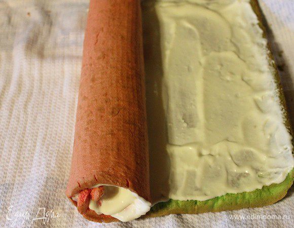 Для начинки: творог, сметану, ванилин и сахар измельчить с помощью погружного блендера. Желатин замочить в холодной воде на 10 минут. Потом распустить в микроволновке. К творожной массе добавить распущенный и процеженный желатин. Перемешать. Освободить остывший рулет от полотенца, смазать его кремом. Завернуть, начиная с красной стороны.




