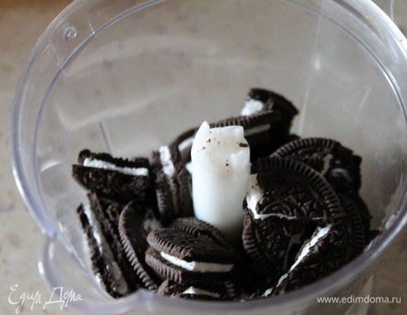 Печенье разломать на кусочки и измельчить с помощью блендера в мелкую крошку.
