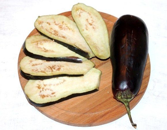 Подготовим баклажан. Отрезаем у баклажана хвостик и нарезаем 8 пластин толщиной 0,5 см.
