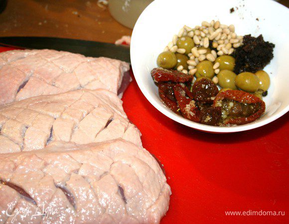 Подготовить ингредиенты: утиные грудки, вяленые томаты, оливки, маслины, кедровые орешки. На грудках сделать продольные разрезы по коже, не трогая само мясо. При желании можно на полчаса замариновать мясо в апельсиновом соке с чесноком.