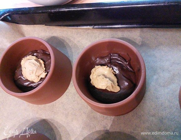 Формочки наполнить тестом, приблизительно 2 ст. л., далее выложить ореховую пасту ~ 1/2 ч. л. Надо учитывать, что паста осядет на дно, и если вы хотите, чтобы она оказалась именно в середине десерта, то нижний слой теста должен быть потолще. 