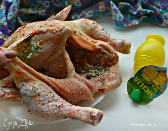 Кожу со стороны ночек у курицы подденьте и оттяните. Положите внутрь масляную смесь и равномерно распределите по ножкам и грудке. Внутри курицу также немного смажьте масляной смесью.