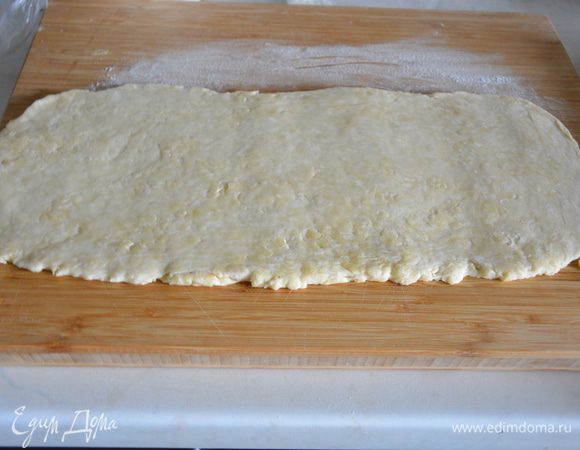 Достать тесто из холодильника и раскатать в длинный пласт на доске, присыпленной мукой. Мука в подразделе «Слоеное тесто, масляный слой» — для раскатки теста. 