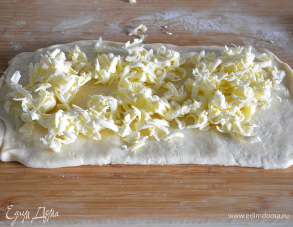 Сверху натереть на терке 100 г очень сильно охлажденного сливочного масла. Повторить пункты 7, 8, 9. То есть, сложить тесто краями друг на друга, как на картинке в п. 7. Раскатать по сгибу — п. 8 Сложить краями друг на друга, раскатать по сгибу, сложить пополам, завернуть в пакет и убрать в холодильник на час.