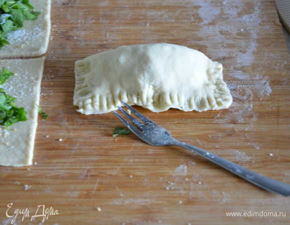 Смазать края квадратиков кисточкой с водой, накрыть половинки и защипать края вилкой. Сверху сделать 3 надреза.