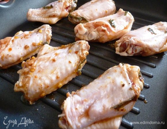 На хорошо разогретую сковороду-гриль выкладываем крылышки.