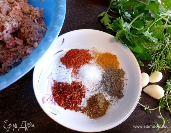 Подготовим продукты для кебабов. У меня фарш из котлетной говядины, так и было написано на упаковке. Перекручиваем с луком на мясорубке.
Из пряностей у меня черный и красный перец, сладкая паприка, паприка копченая, сухая аджика, соль и щепотка сахара. Из трав у меня петрушка, укроп и тимьян. Зелени не жалейте, берите все, что есть в холодильнике: кинза, базилик, молодой чеснок, мята тоже подойдут. Еще возьмем зубчики чеснока.