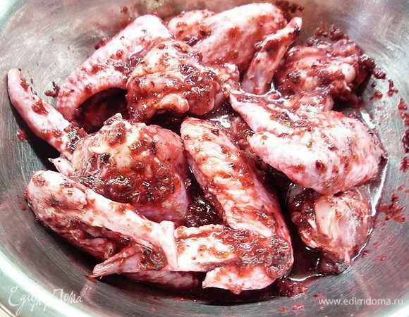 Куриные крылья промываем, просушиваем, надрезаем у суставов и заливаем получившимся ягодным маринадом. Оставляем на два часа в холодном месте, накрыв пищевой пленкой.