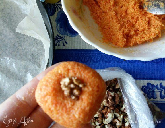 Берем кусочек теста, на середину кладем грецкий орех, делаем шарик. Выкладываем готовое печенье на противень. Тесто немного липнет к рукам. Это нормально.