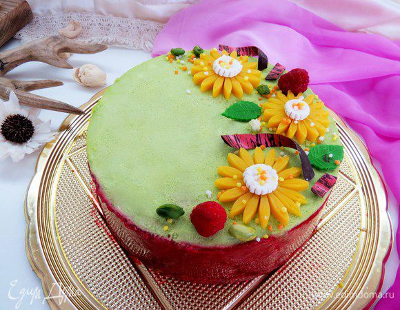 На конфи выкладываем фисташковый чизкейк, ставим в холодильник на полчасика-час, чтобы наш чизкейк стабилизировался. Украшаем по желанию. У меня цветы из марципана, шоколадные завитки, очищенные фисташки, шоколадные листики, ягоды малины.