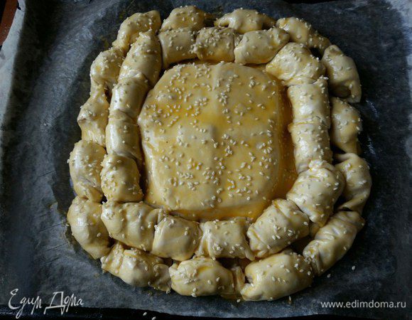 Взбиваем желток и смазываем пирог, посыпаем кунжутом. И отправляем в разогретую духовку при 180°С на 40 минут до зарумянивания.